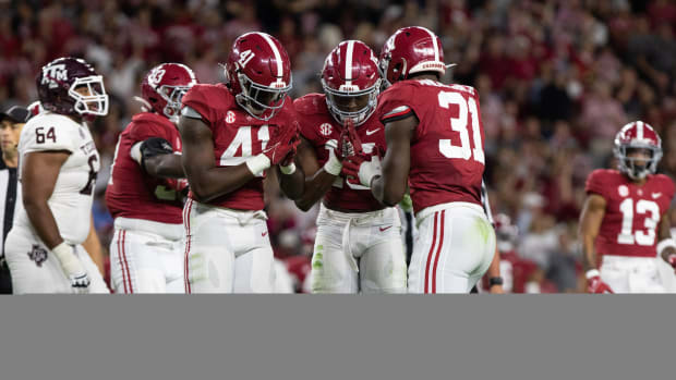 Chris Braswell, Dallas Turner and Will Anderson Jr. celebrate
